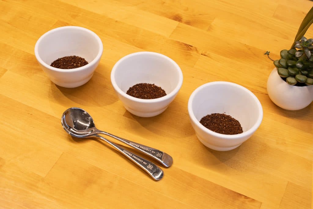 Three cupping bowls with coffee grounds inside.